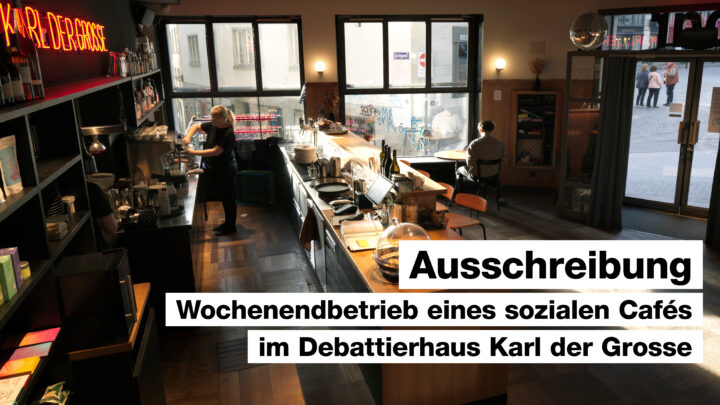 Das Bild zeigt das Bistro Karl der Grosse in Nachmittagsstimmung, mit einer Mitarbeiterin an der Kaffeemaschine und einem Gast an einem der kleinen runden Tische.